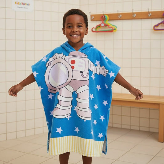 Child wearing a blue astronaut-themed towel in a bathroom setting