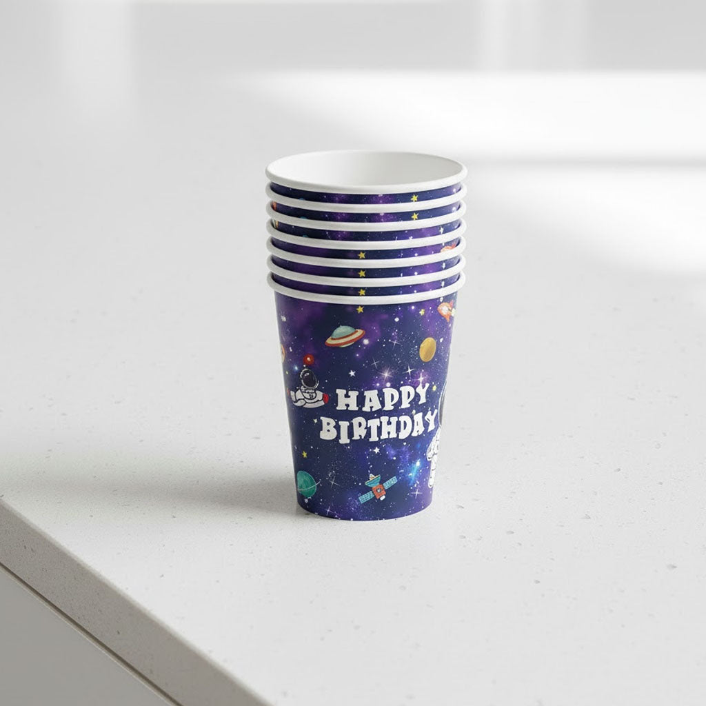 Stack of purple 'Happy Birthday' party cups with space-themed design on a white surface.