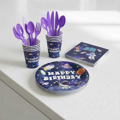 Space-themed birthday party supplies including plates, cups, and utensils on a white surface.